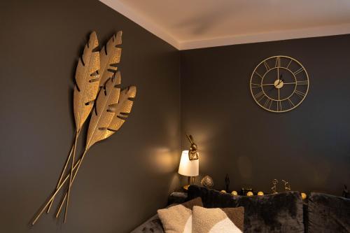 a clock on the wall next to a room with a bed at Reigi Holiday Home, Hiiumaa with Nordic HotTub & Sauna in Reigi