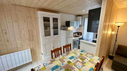 une petite cuisine avec une table et une cuisine gmaxwell gmaxwell gmaxwell gmaxwell dans l'établissement Les Myrtilles Le Mont Dore 6pers, à Le Mont-Dore