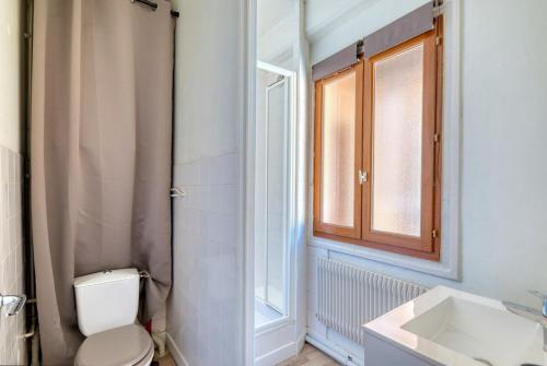 une salle de bain avec toilettes, lavabo et fenêtre dans l'établissement Studio cosy - Plein coeur de Neuville, à Neuville-sur-Saône