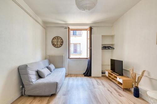 un salon avec un canapé et une télévision dans l'établissement Studio cosy - Plein coeur de Neuville, à Neuville-sur-Saône