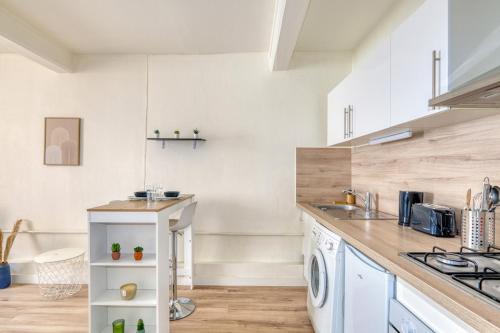 Il comprend une cuisine équipée d'un lave-linge et d'un sèche-linge. dans l'établissement Studio cosy - Plein coeur de Neuville, à Neuville-sur-Saône