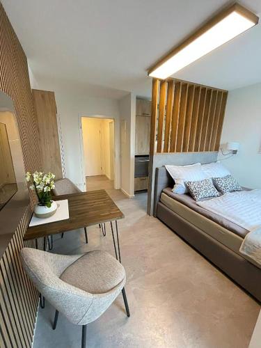 a living room with a bed and a table and a couch at Vision - Apartment 27 - Bad Klosterlausnitz in Bad Klosterlausnitz