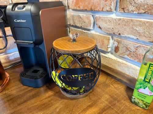 a coffee dispenser with a wooden top next to a brick wall at Monialuki in Nogat