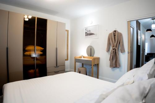 a bedroom with a white bed and a dressing table at Le Loft Bleu in Petite Île