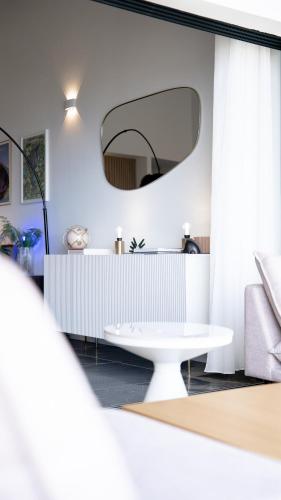 a room with a white table and a mirror at Le Loft Bleu in Petite Île