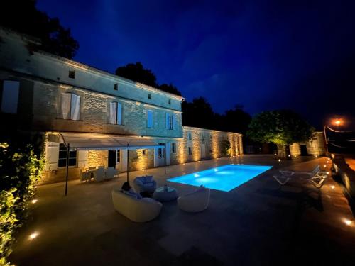 a swimming pool in front of a building at night at Ancien Château viticole in Bourg-sur-Gironde