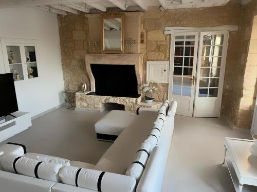 a living room with a couch and a fireplace at Ancien Château viticole in Bourg-sur-Gironde