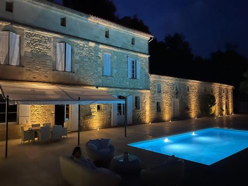 a swimming pool in front of a building at night at Ancien Château viticole in Bourg-sur-Gironde