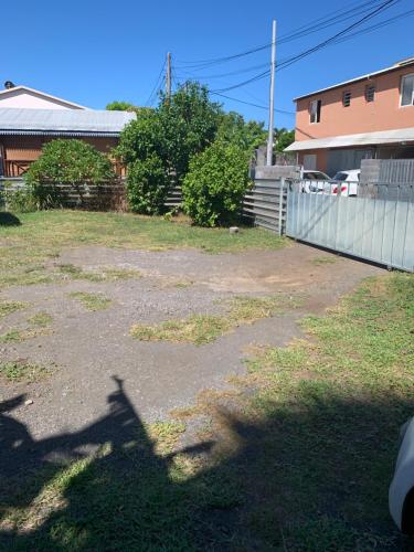a driveway in a yard with a fence and a house at Suite parentale in Saint-Pierre