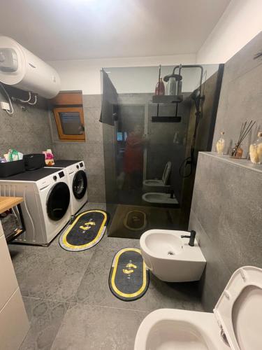 a bathroom with a toilet and a washing machine at Apartman Bajt in Ravna Gora