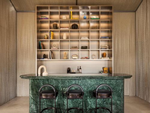 シンガポールにあるMondrian Singapore Duxtonのテーブルとスツール2脚付きの部屋