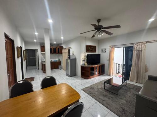 a living room with a dining table and a ceiling fan at Kotchaporn garden in Pattaya South