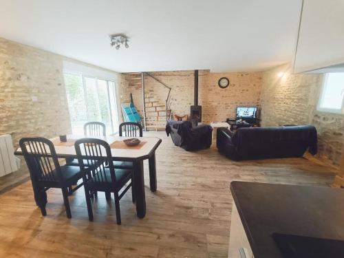 un salon avec une table, des chaises et un canapé dans l'établissement Charming House Between Land & Sea, à Barbery