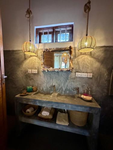 a bathroom with a sink and a mirror at Olamanga Beach Villa Adults Only in Jambiani