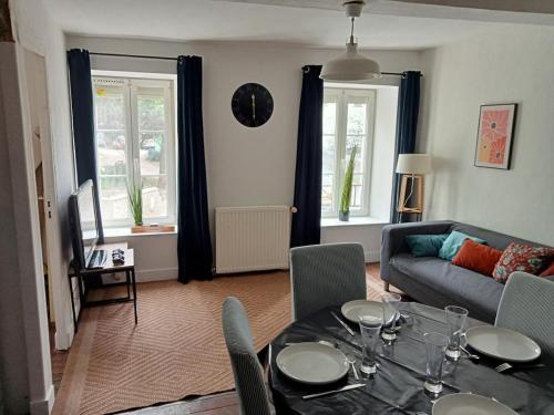 un salon avec une table et un canapé dans l'établissement Close to Beaches and Bayeux, à Tour-en-Bessin