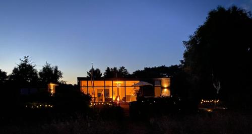 a house lit up at night in a field at Bright and modern villa by the sea in Trelleborg