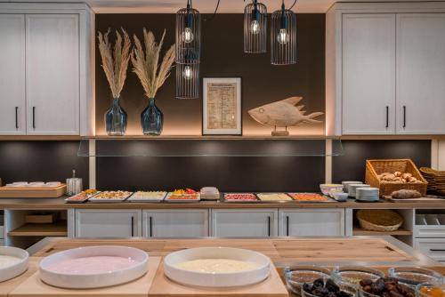 a kitchen with a counter with plates of food at Hotel Inselfriede in Spiekeroog