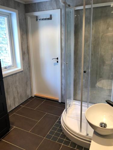 a bathroom with a shower and a sink at Neiden hytten in Neiden