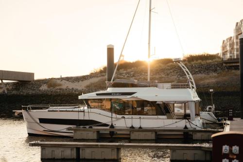 a boat docked at a dock in the water at Yacht by Strandhotel - hotel service & wellness in Cadzand