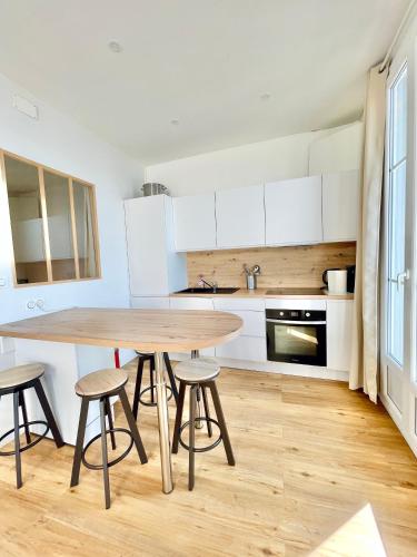 - une cuisine avec une table et des tabourets en bois dans l'établissement Promenade des Anglais panoramic sea view, à Nice