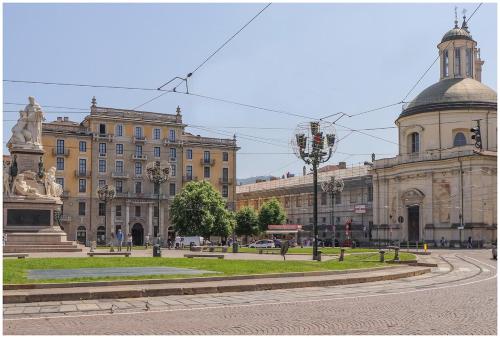 a building with a statue in the middle of a street at Carlina Charme 10 minutes from Porta Nuova - WIFI in Turin