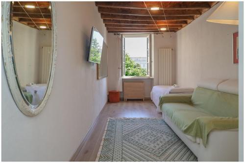 a living room with a couch and a mirror at Carlina Charme 10 minutes from Porta Nuova - WIFI in Turin