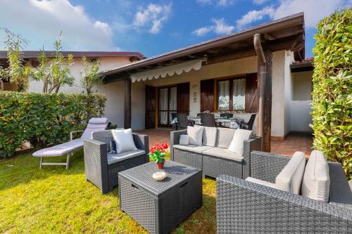 patio z wiklinowymi krzesłami i stołami na dziedzińcu w obiekcie Villa Bellavista con piscina w mieście Soiano del Lago