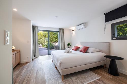 une chambre avec un lit et une grande fenêtre dans l'établissement VILLA ST BASILE - Villa Unique - Contemporaine - Piscine - Climatisation, à Mougins