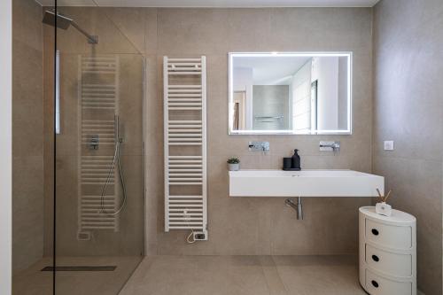 une salle de bain avec un lavabo, un miroir et une douche dans l'établissement VILLA ST BASILE - Villa Unique - Contemporaine - Piscine - Climatisation, à Mougins