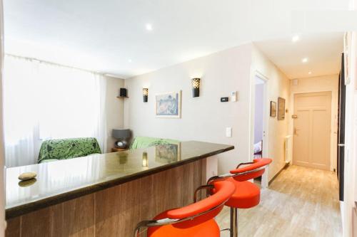 Cette chambre dispose d'un bar avec des chaises orange. dans l'établissement My appartement Perpignan 50m2, à Perpignan