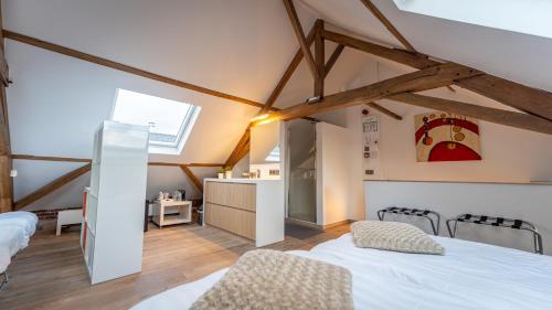 a attic room with two beds and a kitchen at Maison de la Paix in Poperinge