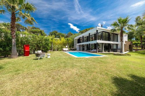 une vue extérieure d'une maison avec piscine dans l'établissement VILLA ST BASILE - Villa Unique - Contemporaine - Piscine - Climatisation, à Mougins