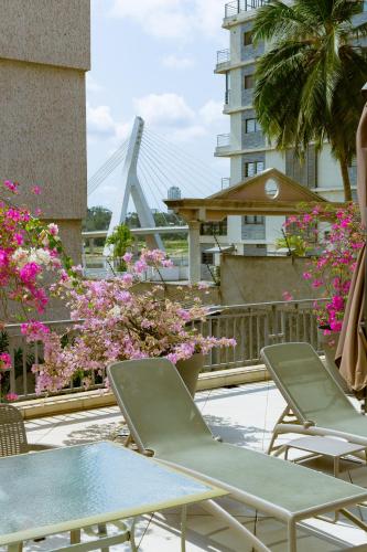 a row of chairs and tables on a balcony with flowers at Résidences Les Hauts de l'Indenié in Abidjan