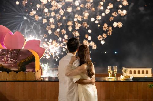 a bride and groom standing in front of a cake with fireworks at Sakurakyo Hotel & Spa Phu Quoc - Free Hon Thom Island Waterpark Cable Car Until 15 December 2025 in Phu Quoc