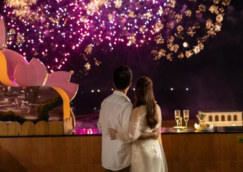 a bride and groom standing in front of a bar with fireworks at Sakurakyo Hotel & Spa Phu Quoc - Free Hon Thom Island Waterpark Cable Car Until 15 December 2025 in Phu Quoc