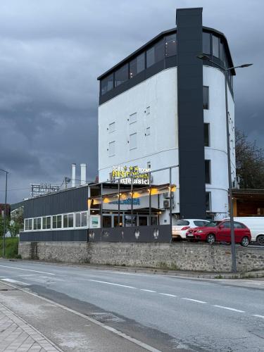 a building with cars parked in a parking lot at Rooms & Spa BJELASICA in Bijelo Polje