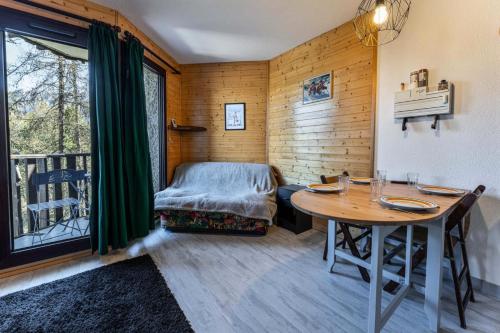 une chambre avec une table et un lit et un balcon dans l'établissement Résidence L'oustal - Agréable 2 pièces proche du centre 1650 MAE-3441, aux Orres