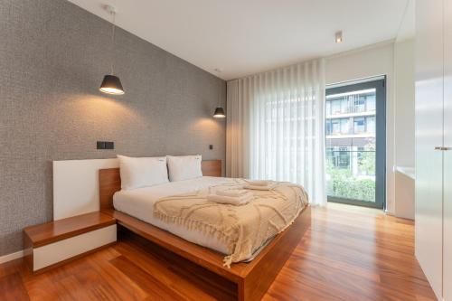 a bedroom with a bed and a large window at FLH Funchal Elegant Apartment with Pool & Balcony in Funchal