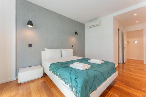 a bedroom with a bed with two towels on it at FLH Funchal Elegant Apartment with Pool & Balcony in Funchal