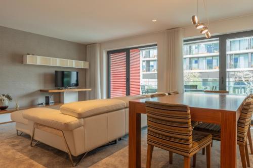 a living room with a dining room table and chairs at FLH Funchal Elegant Apartment with Pool & Balcony in Funchal