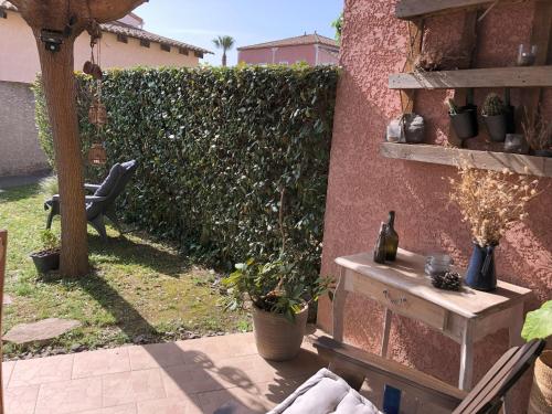 un patio avec une clôture avec des plantes et une table dans l'établissement Logement 4 pers - Béziers au bord du Canal du Midi à prox des plages, à Béziers