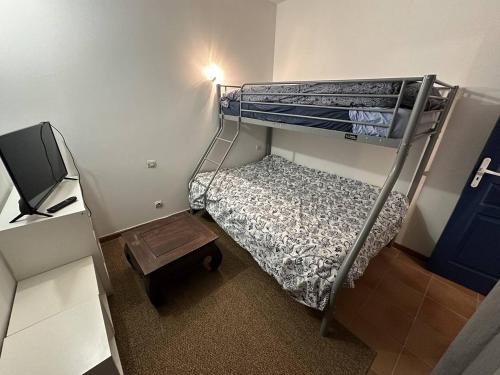 a small room with a bunk bed and a television at Appartement T3 - centre ville - climatisation - internet in Saintes-Maries-de-la-Mer