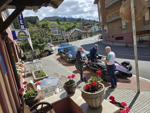 a group of men standing around a motorcycle on a street at Hosteria Picos De Europa in Potes