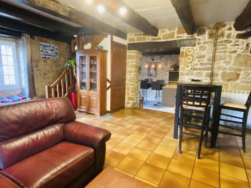 un salon avec un canapé en cuir et une cuisine dans l'établissement La HULOTTE, à Balsac