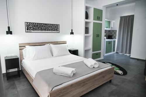 a bedroom with a large bed with two towels on it at The Friend's House Milos in Triovasálos