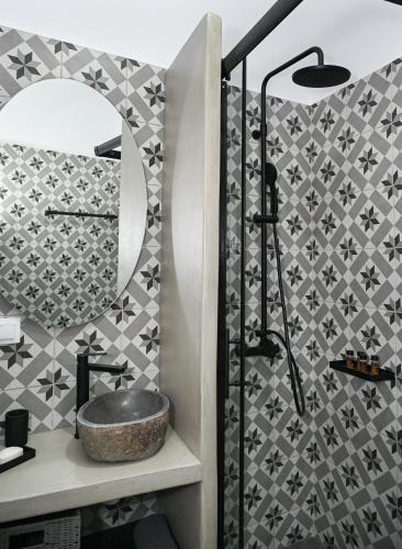 a bathroom with a sink and a mirror at The Friend's House Milos in Triovasálos