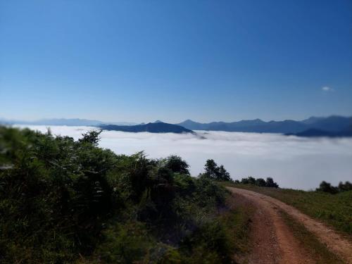 a dirt road on a hill with a sea of clouds at Hosteria Picos De Europa in Potes