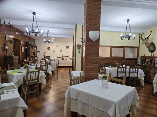 a restaurant with tables and chairs with white table cloth at Hosteria Picos De Europa in Potes