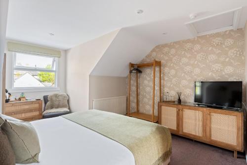 a bedroom with a bed and a flat screen tv at Falmouth Bay in Falmouth
