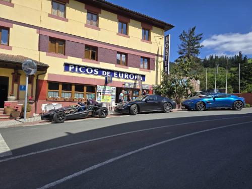 three luxury cars parked in front of a building at Hosteria Picos De Europa in Potes